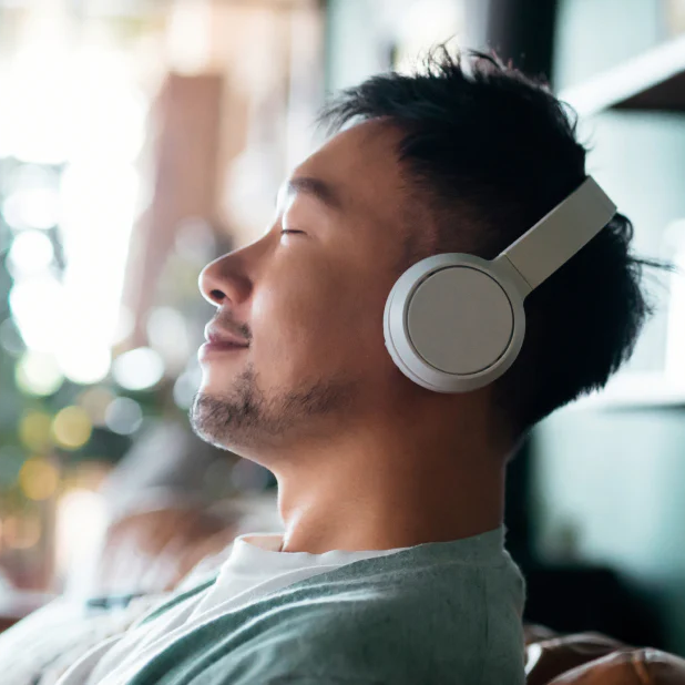 Man listening to something pleasing on their over ear headphones.